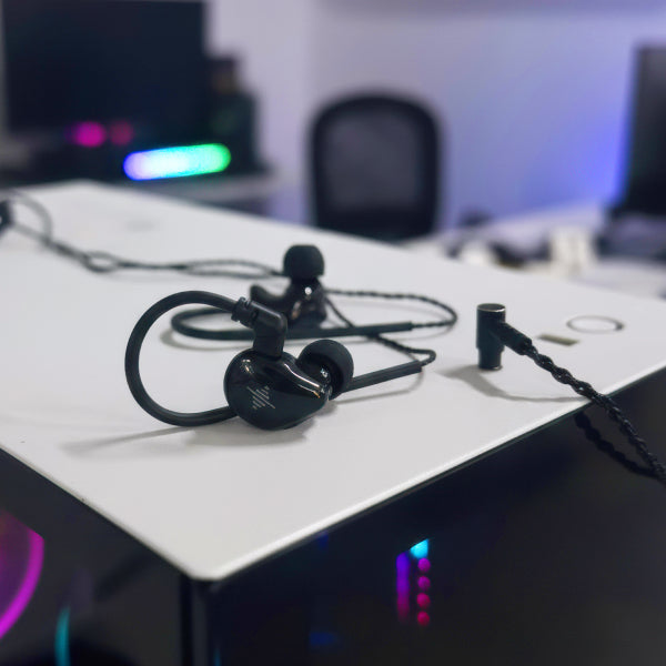 Black wired in-ear earphones on a white desk