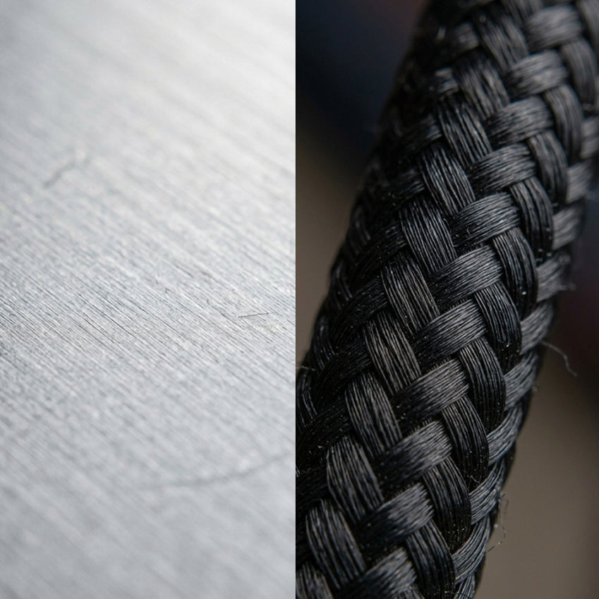 Close-up of a black braided audio cable beside a gray surface