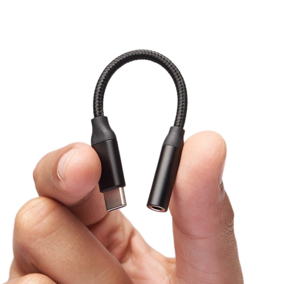 手持黑色 USB-C 转 3.5mm 音频适配器