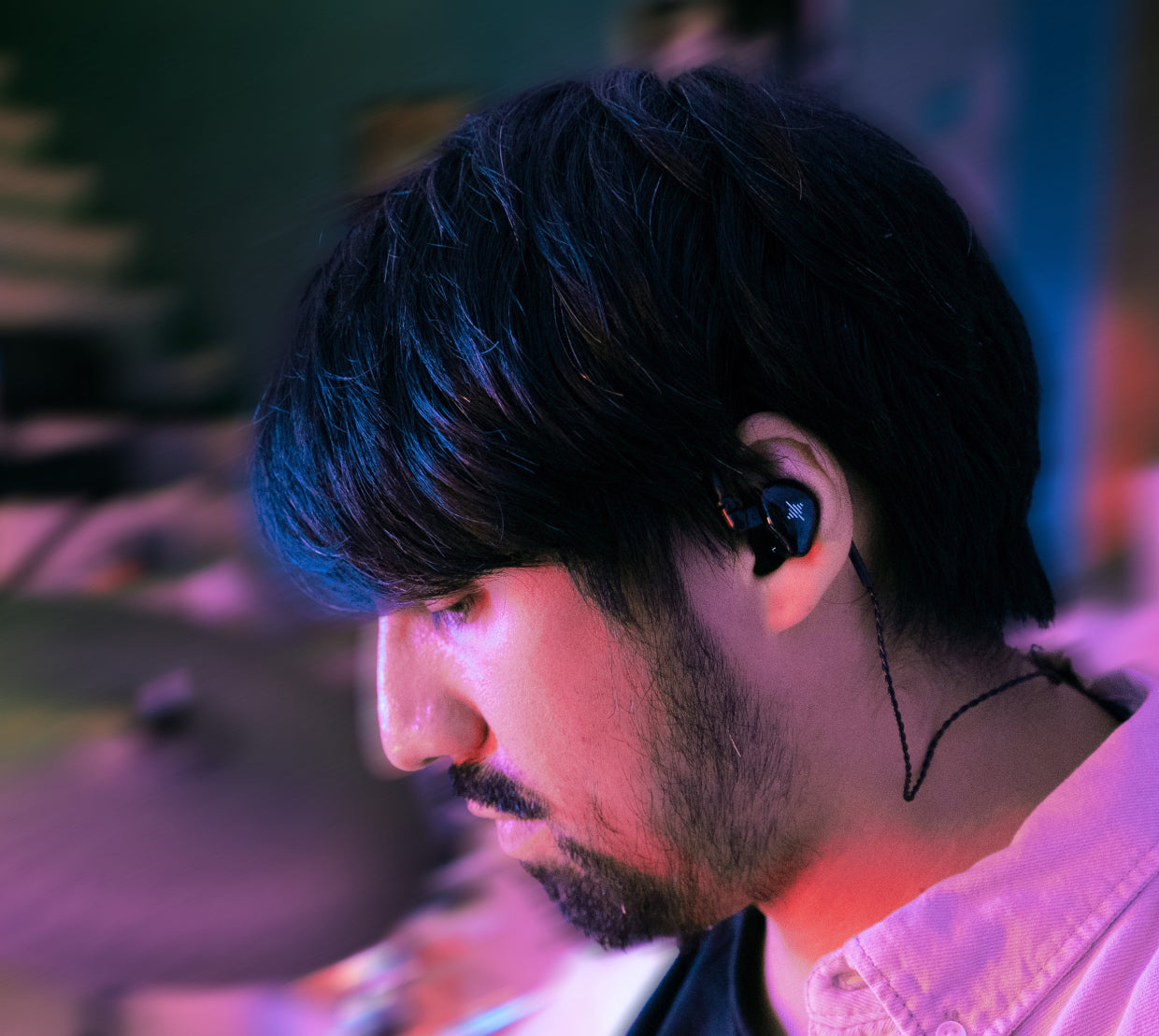 Close-up of a man wearing a black in-ear monitor