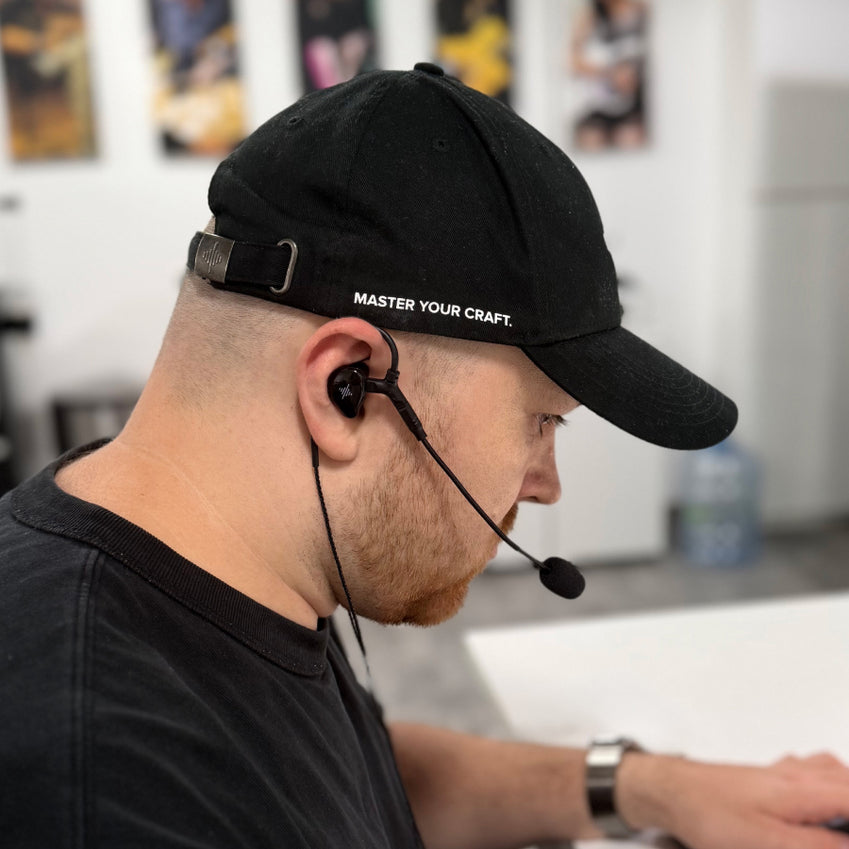 Person wearing a black in-ear monitor and headset microphone
