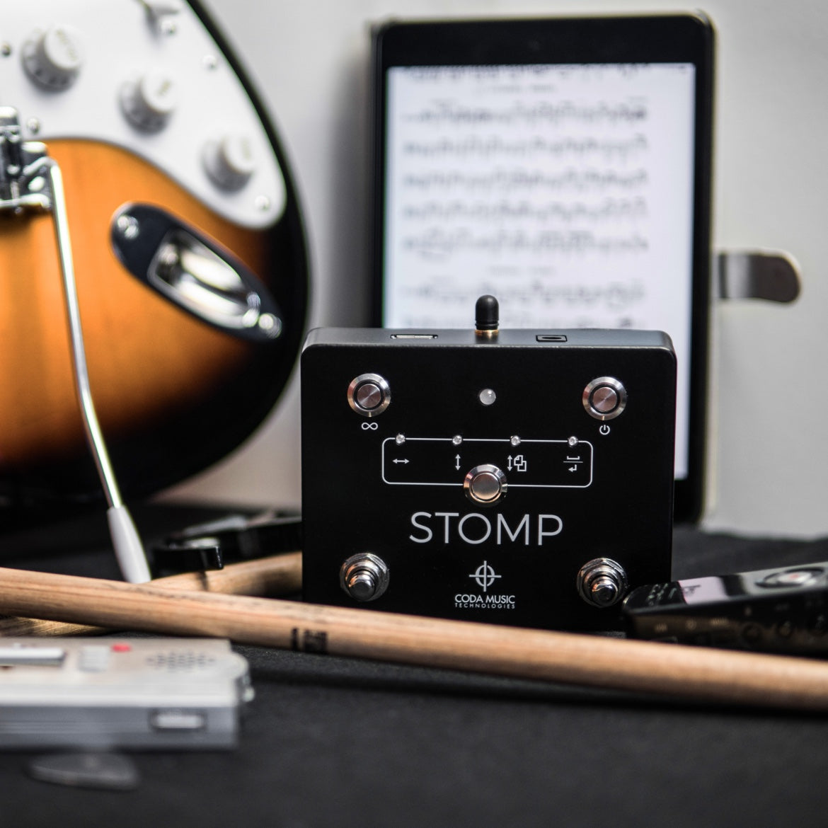 搭配吉他、平板电脑和鼓槌的 Soundbrenner Stomp 脚踏板